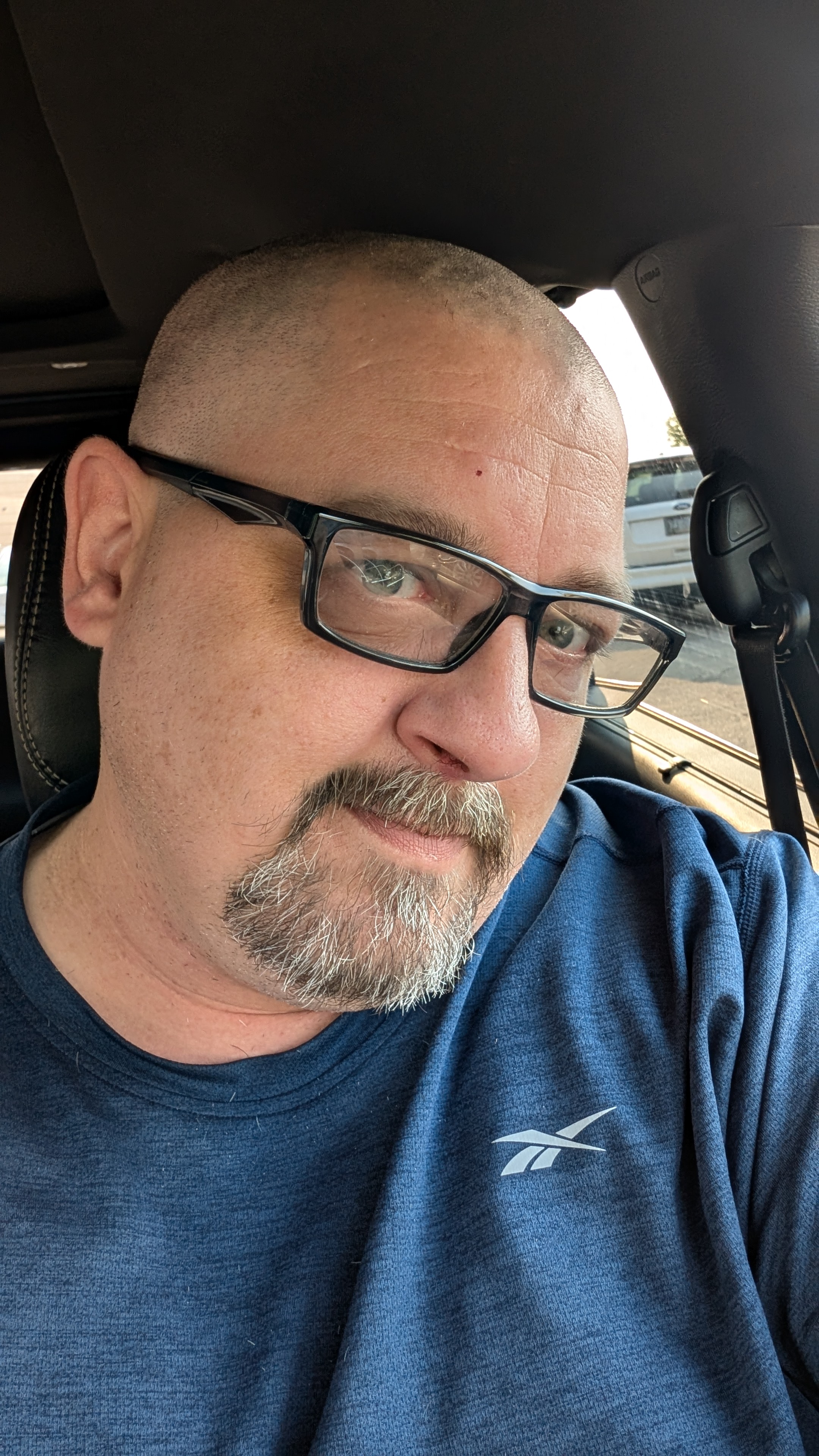 Portrait of Chad wearing glasses in a blue shirt